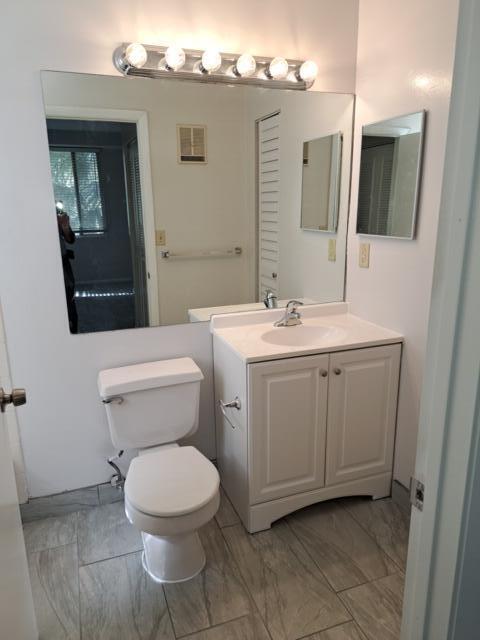 701 Lyons Road, Unit 13208 Coconut Creek, FL 33063 - Photo 11 of 31 a bathroom with a toilet sink and mirror