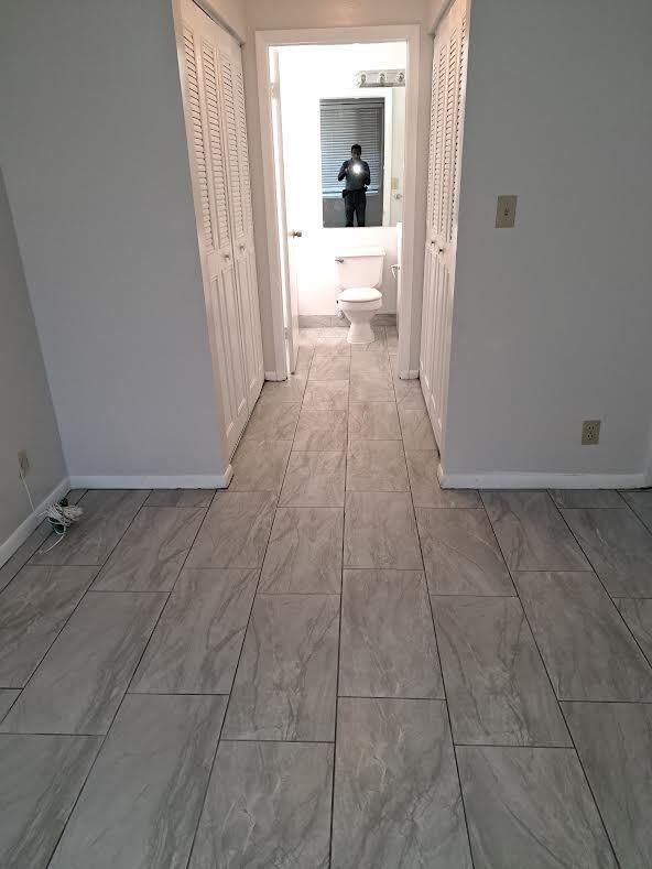 701 Lyons Road, Unit 13208 Coconut Creek, FL 33063 - Photo 16 of 31 a hallway with a view of bedroom with a bathtub