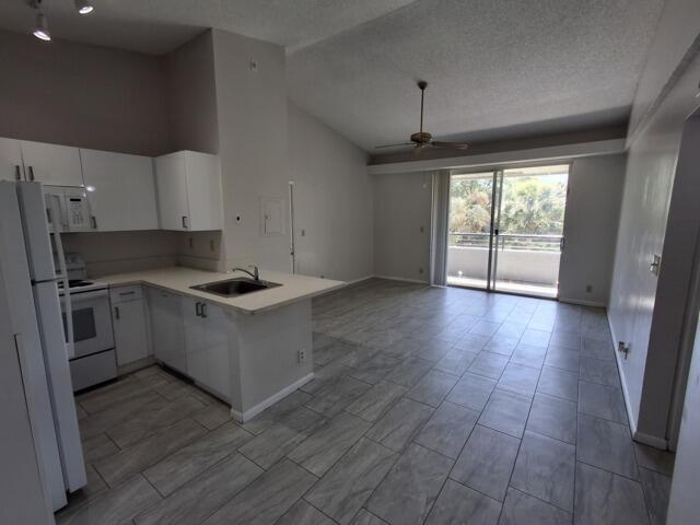 701 Lyons Road, Unit 13208 Coconut Creek, FL 33063 - Photo 5 of 31 a kitchen with granite countertop a stove cabinets and wooden floor