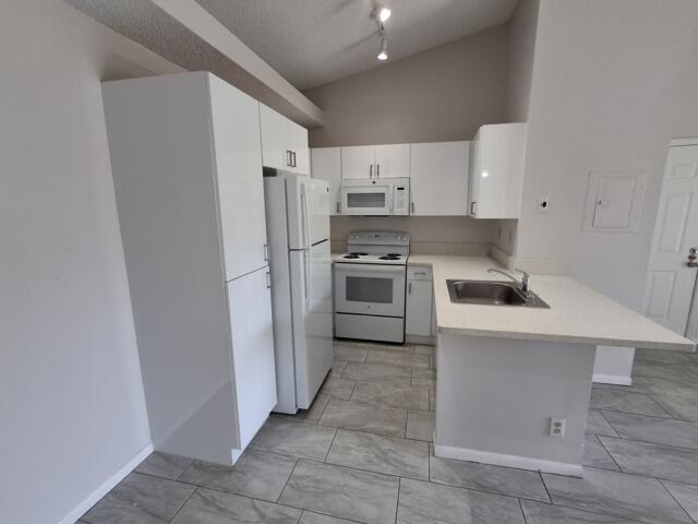701 Lyons Road, Unit 13208 Coconut Creek, FL 33063 - Photo 6 of 31 a kitchen with a stove sink and refrigerator