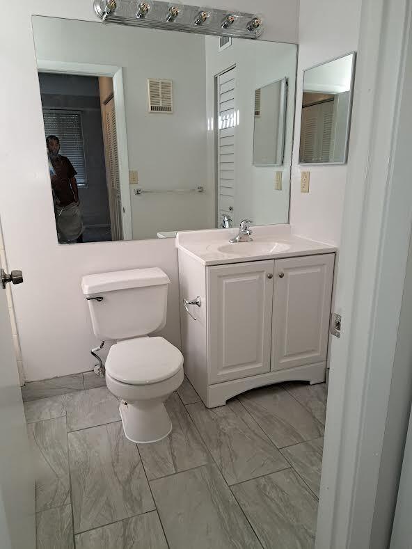701 Lyons Road, Unit 13208 Coconut Creek, FL 33063 - Photo 9 of 31 a bathroom with a toilet sink and mirror