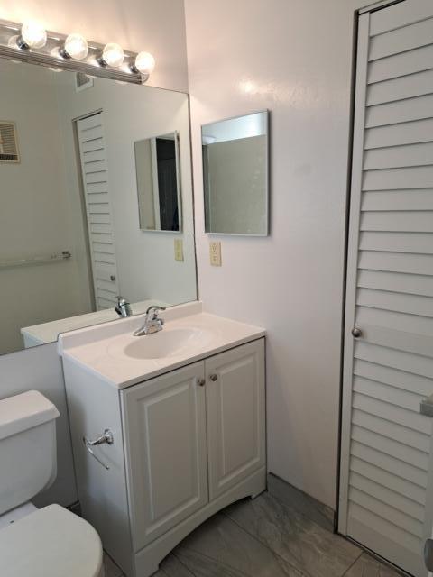 701 Lyons Road, Unit 13208 Coconut Creek, FL 33063 - Photo 10 of 31 a bathroom with a toilet sink and mirror