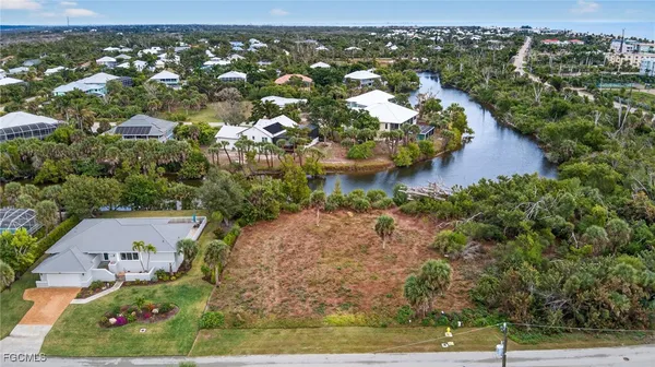 an aerial view of residential houses with outdoor space and trees