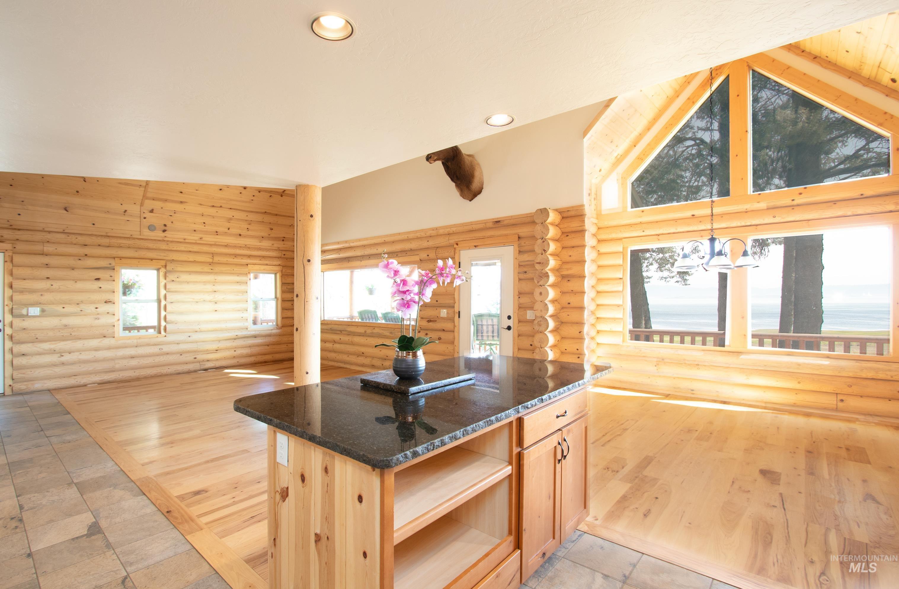 1539 West Mountain Road Cascade, ID 83611 - Photo 8 of 33 Kitchen with log walls, light wood finish cabinets, light wood-style floors, dark stone countertops, and recessed lighting