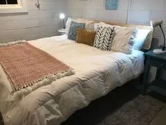 a large bed with white sheets and pillows