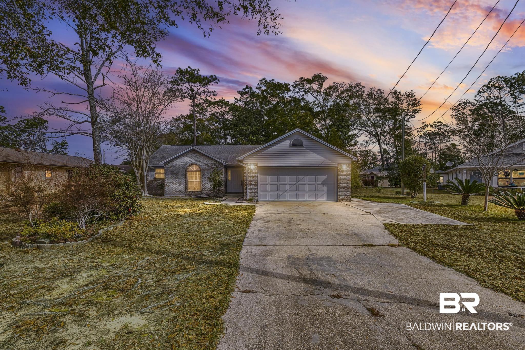 2776 Santa Rosa Circle Lillian, AL 36549 - Photo 1 of 48 Ranch-style home with a front yard, brick siding, concrete driveway, and an attached garage