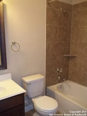 a white toilet and tub sitting next to a bathroom sink