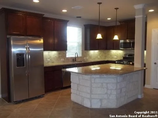 a kitchen with kitchen island a counter space and a refrigerator