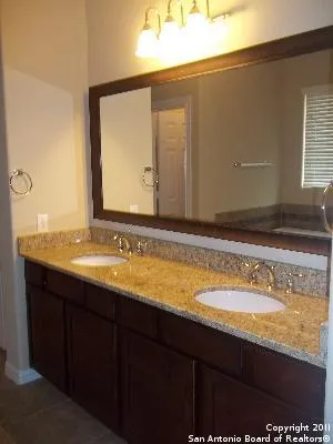 a bathroom with a granite countertop sink and a mirror