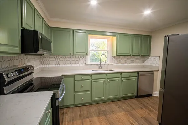 a kitchen with a sink appliances and cabinets