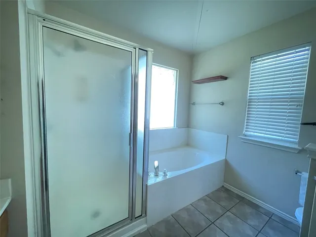 a bathroom with a tub sink shower and mirror