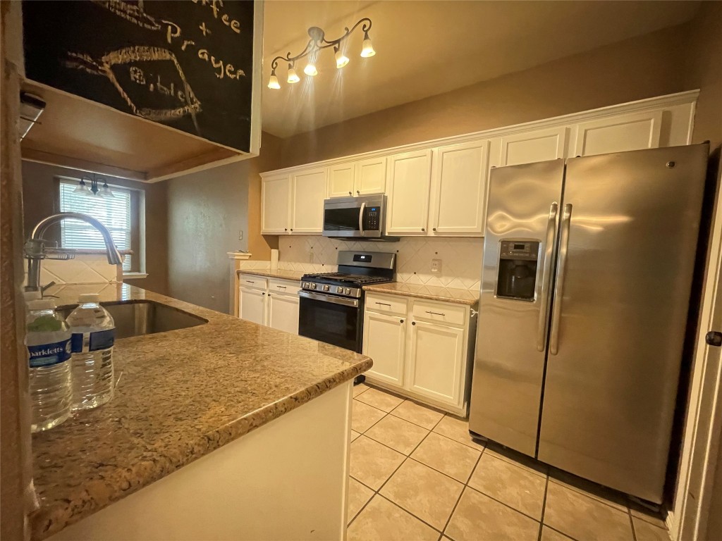 3508 Blue Ridge Drive Round Rock, TX 78681 - Photo 18 of 26 a kitchen with a sink a refrigerator and a stove