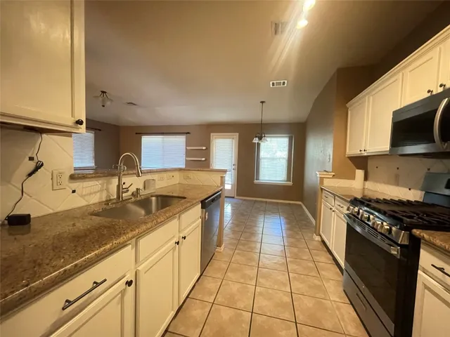 a kitchen with a sink a refrigerator and a stove