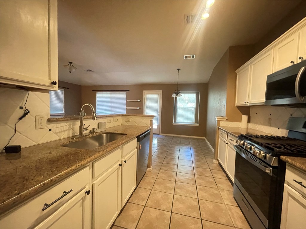 3508 Blue Ridge Drive Round Rock, TX 78681 - Photo 19 of 26 a kitchen with stainless steel appliances granite countertop a sink stove and cabinets