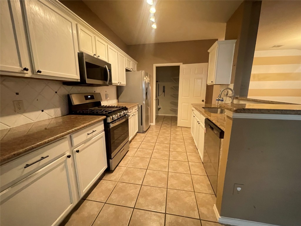 3508 Blue Ridge Drive Round Rock, TX 78681 - Photo 21 of 26 a kitchen with stainless steel appliances granite countertop a stove a sink and a microwave