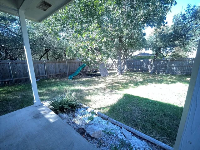a view of yard with tree in the background