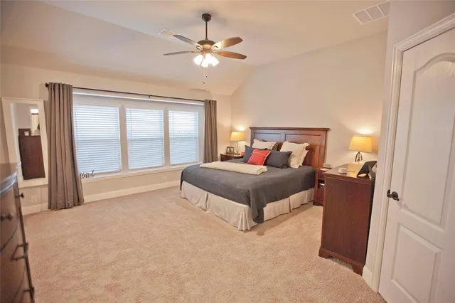 a spacious bedroom with a large bed and a chandelier