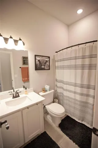 a bathroom with a sink toilet vanity and shower