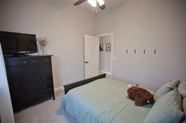 a bedroom with a bed and a flat tv screen on dresser