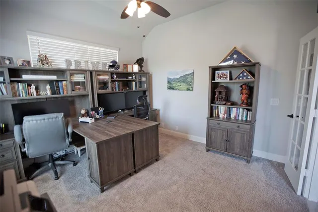 a view of a workspace with furniture and a book shelf