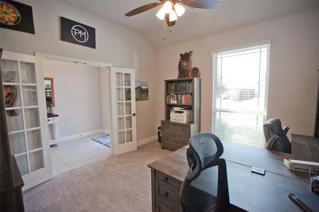 a view of a livingroom with workspace and a window