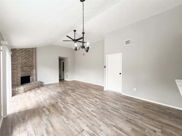 a view of empty room with a fireplace and wooden floor