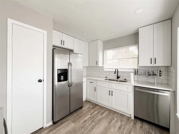 a kitchen with a refrigerator sink and cabinets