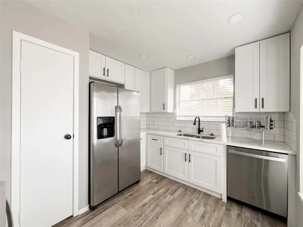 a kitchen with a refrigerator sink and cabinets