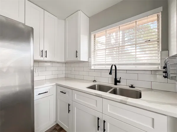 a view with white cabinets and a sink