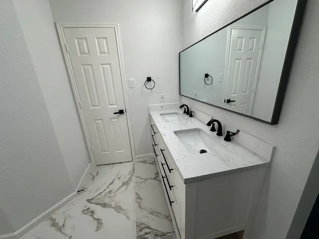 a bathroom with a sink vanity and mirror
