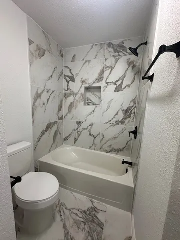 a bathroom with a toilet and a shower