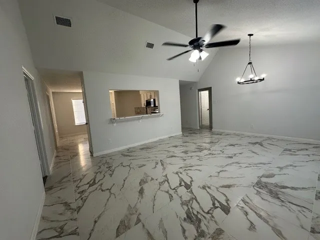 a view of a livingroom with a chandelier fan and wooden floor