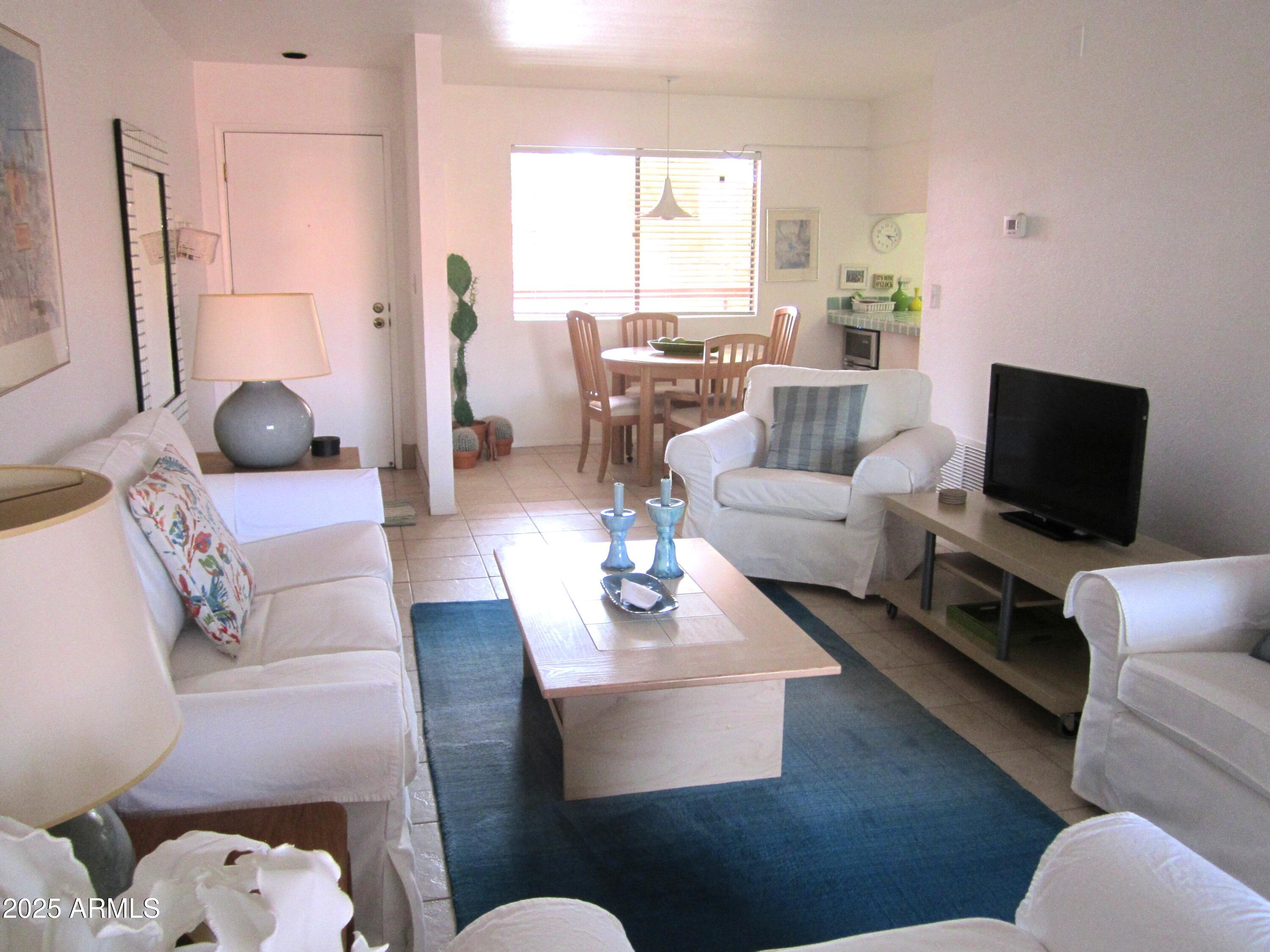 4303 East Cactus Road, Unit 413 Phoenix, AZ 85032 - Photo 12 of 30 a living room with furniture and a flat screen tv