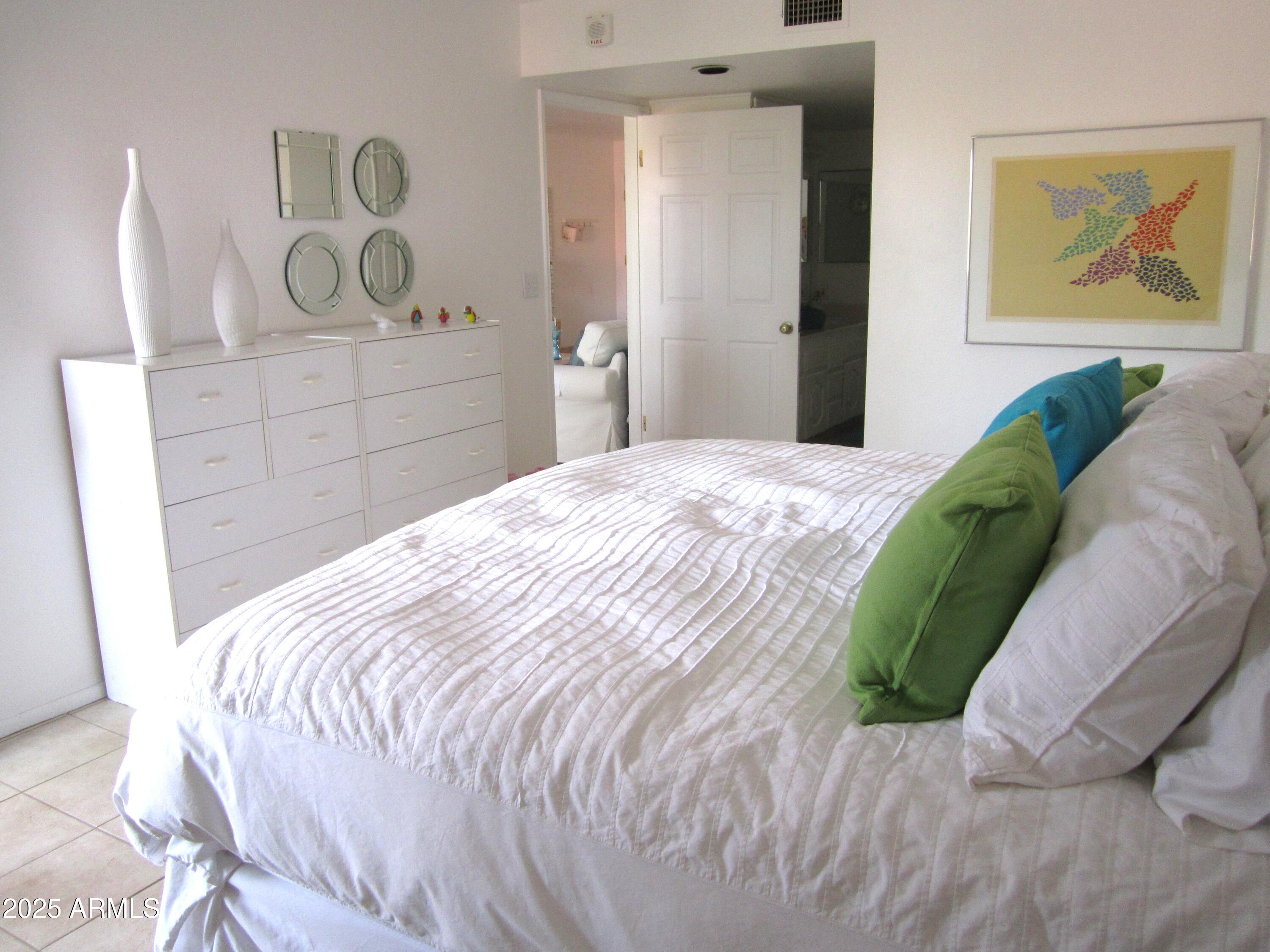 4303 East Cactus Road, Unit 413 Phoenix, AZ 85032 - Photo 13 of 30 a bedroom with a bed and painting on the wall