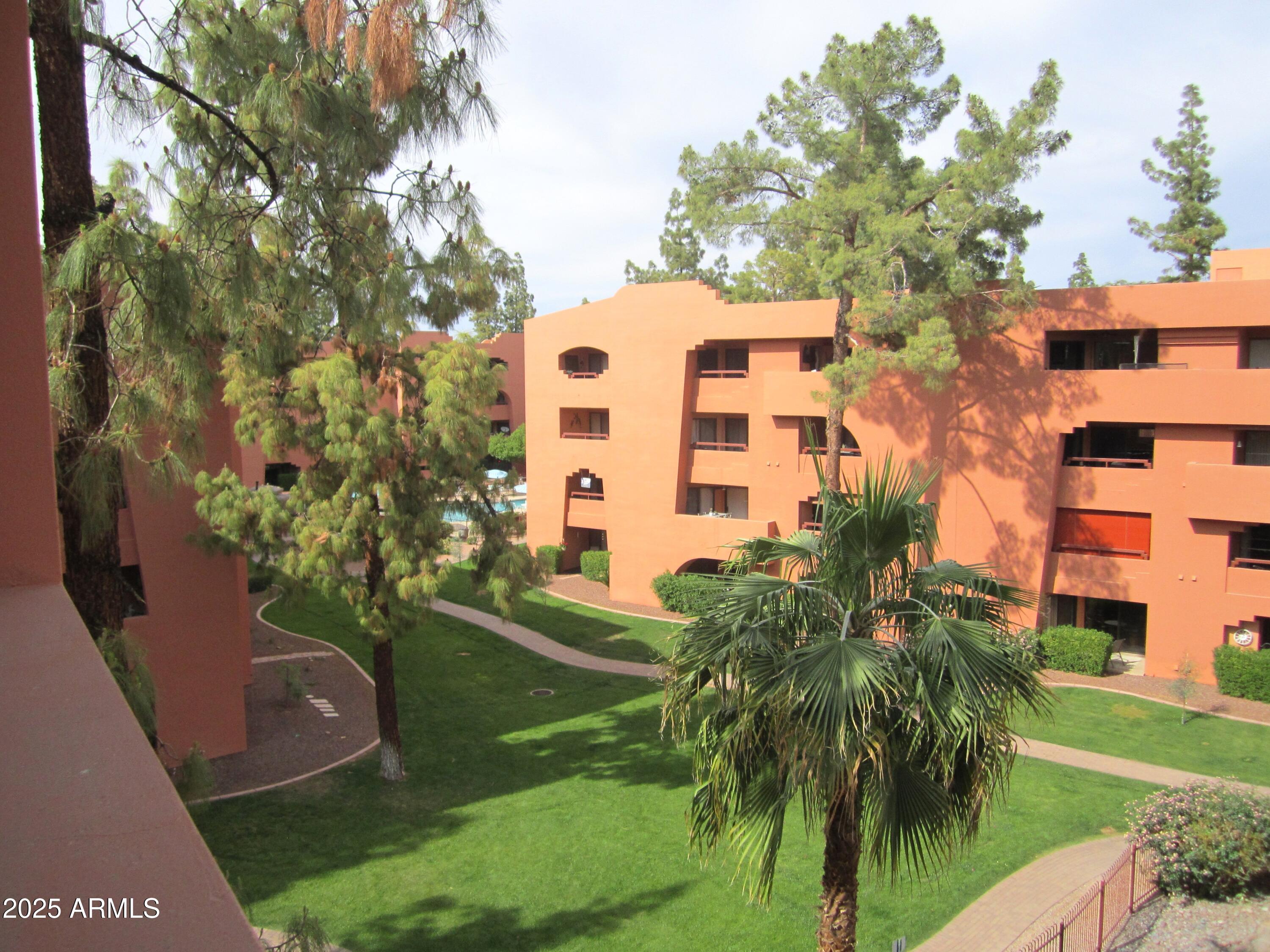 4303 East Cactus Road, Unit 413 Phoenix, AZ 85032 - Photo 16 of 30 a front view of a multi story residential apartment building with yard and outdoor seating