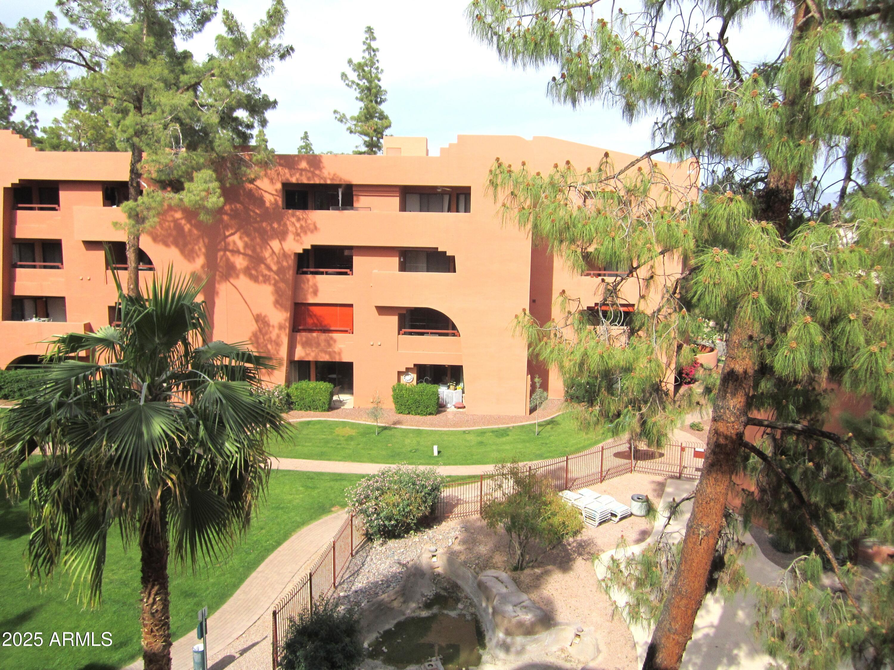 4303 East Cactus Road, Unit 413 Phoenix, AZ 85032 - Photo 19 of 30 a view of a multi story residential apartment building with a yard