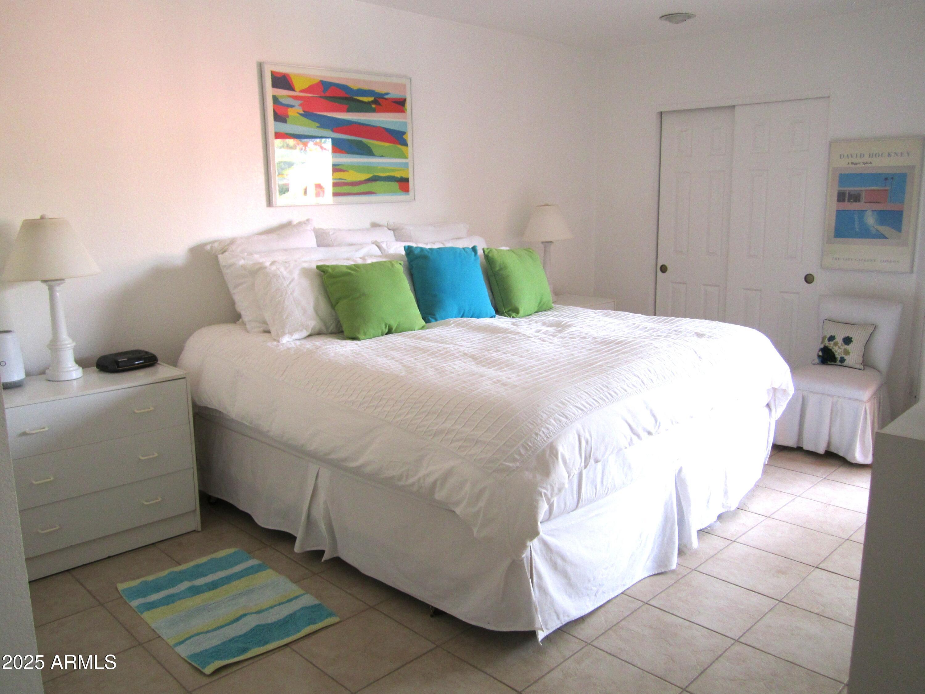 4303 East Cactus Road, Unit 413 Phoenix, AZ 85032 - Photo 4 of 30 a bedroom with a bed and a painting on the wall