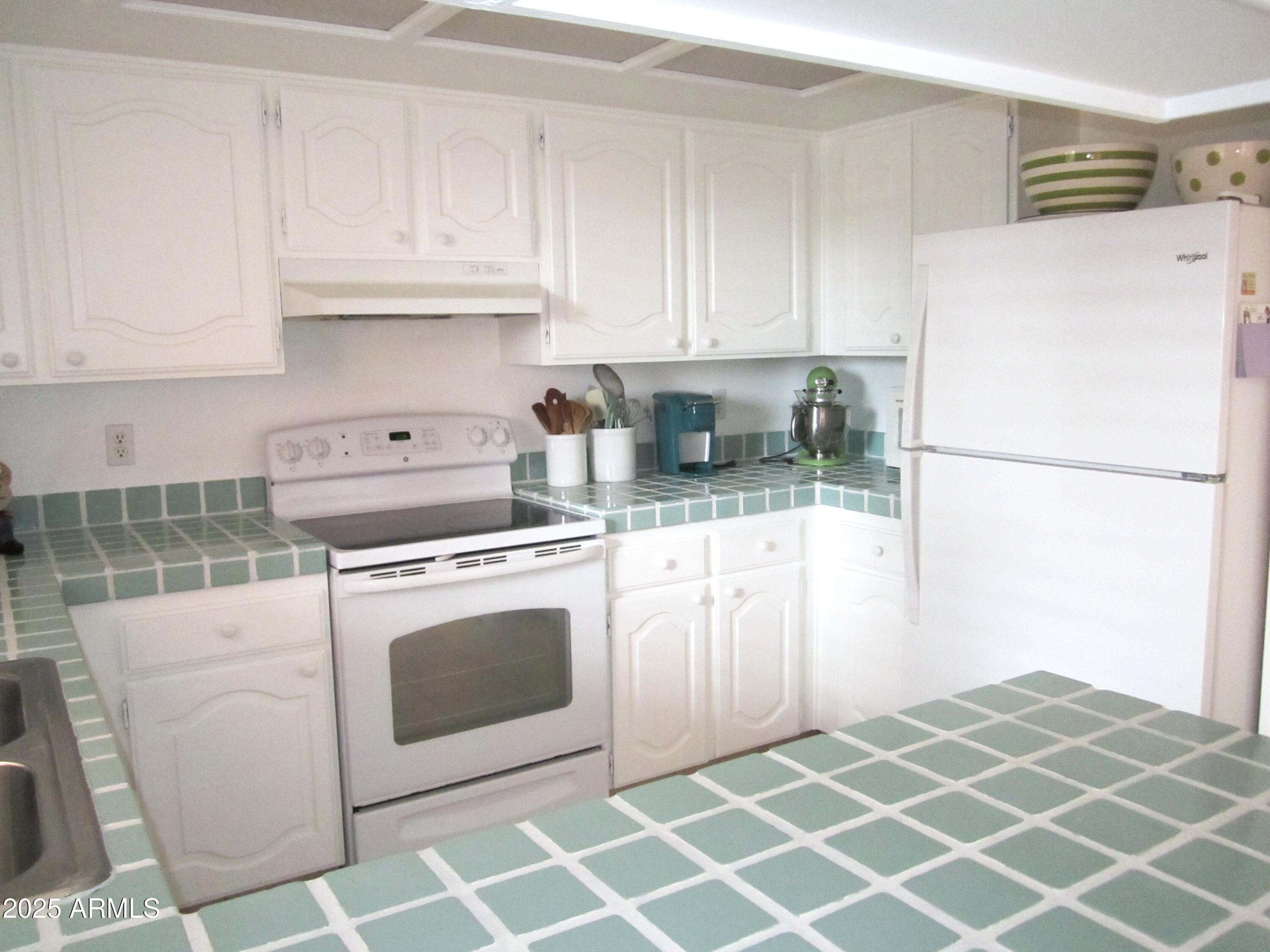 4303 East Cactus Road, Unit 413 Phoenix, AZ 85032 - Photo 8 of 30 a kitchen with stainless steel appliances granite countertop a refrigerator sink and white cabinets