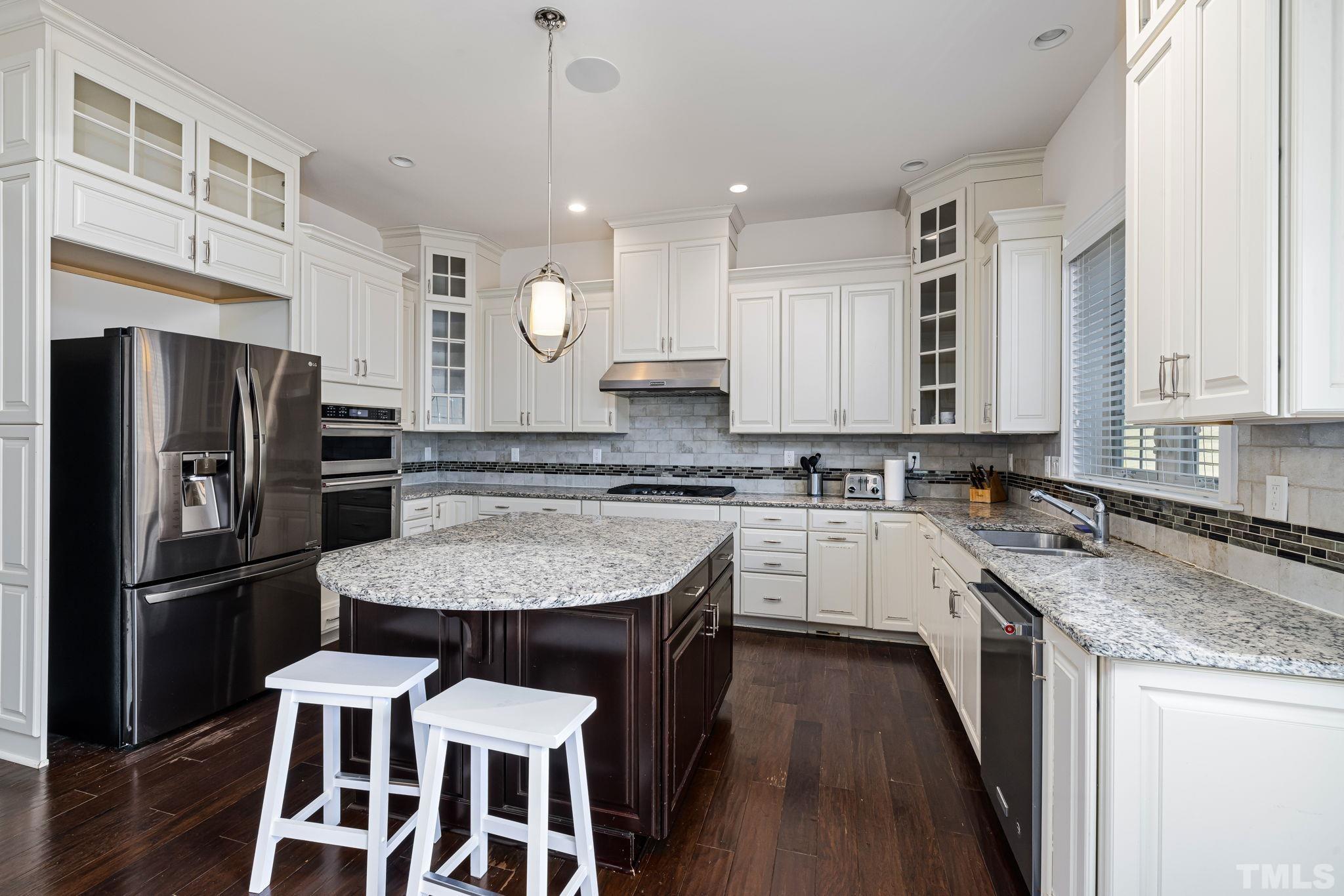 2808 Spring Shade Road Apex, NC 27523 - Photo 13 of 34 a kitchen with a refrigerator a sink dishwasher a stove and white cabinets with wooden floor