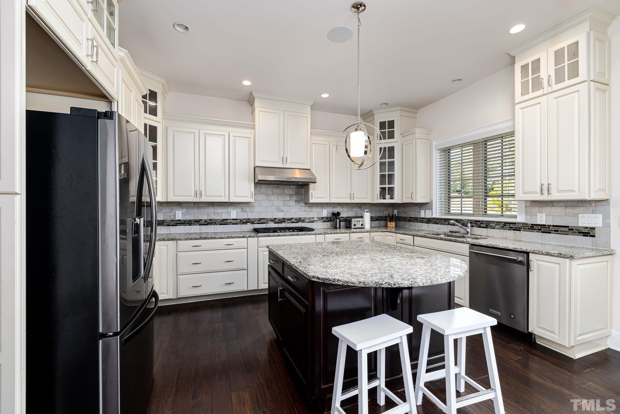 2808 Spring Shade Road Apex, NC 27523 - Photo 14 of 34 a large kitchen with granite countertop a center island stainless steel appliances cabinets and a window