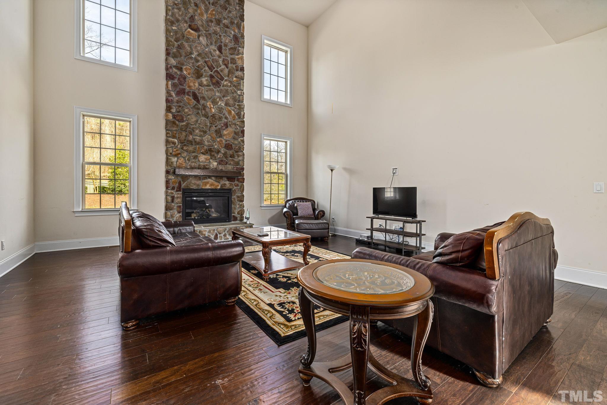 2808 Spring Shade Road Apex, NC 27523 - Photo 9 of 34 a living room with furniture a flat screen tv and a fireplace