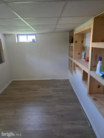 a hallway with hardwood floor and staircase