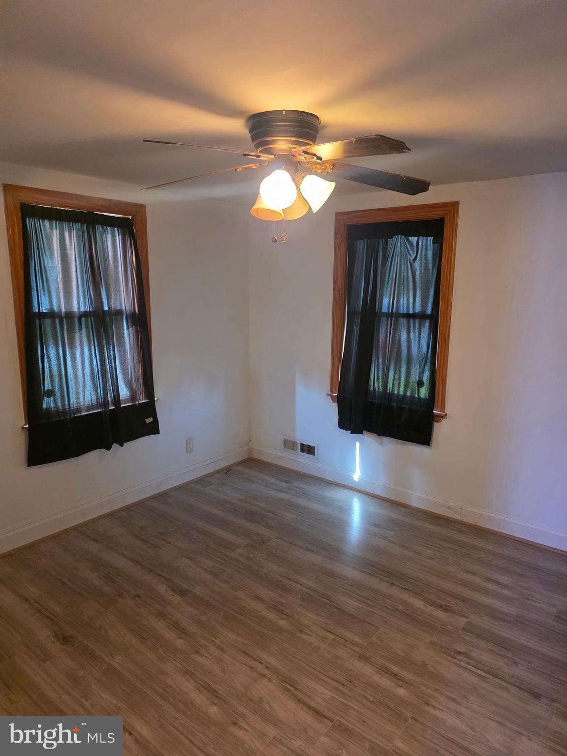 1117 Walker Avenue Baltimore, MD 21239 - Photo 5 of 16 a view of an empty room with window and wooden floor