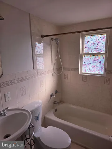 a bathroom with a tub a sink and a shower