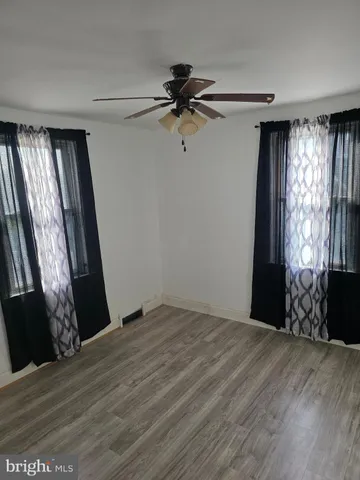 a view of a livingroom with a window and hardwood floor