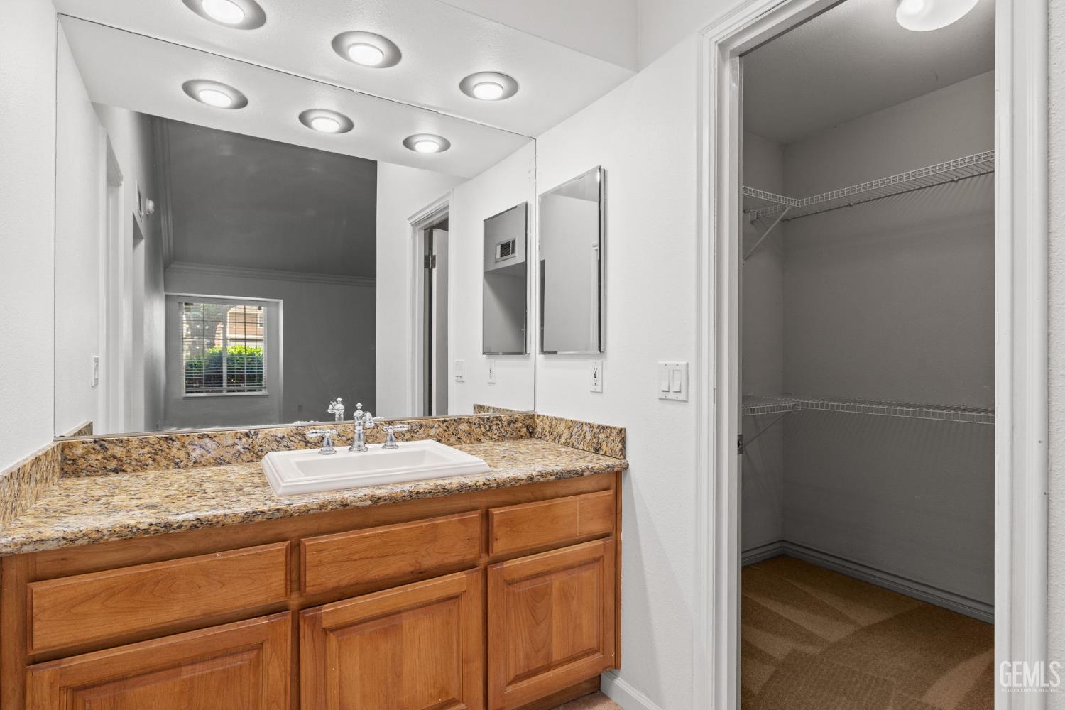 Undisclosed Address Bakersfield, CA 93309 - Photo 31 of 42 a bathroom with a granite countertop sink and a mirror