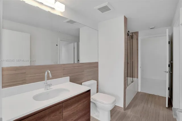 a bathroom with a tub shower vanity and a sink