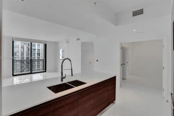 a kitchen with a sink and a large mirror