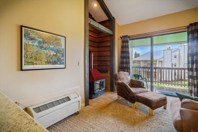 a living room with furniture a flat screen tv and a floor to ceiling window