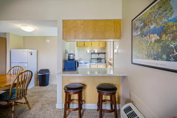 a kitchen with stainless steel appliances a dining table and chairs